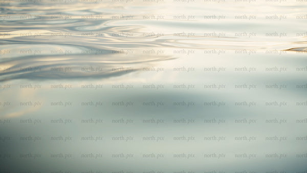 Calm water ripples at sunset: Golden hour reflections