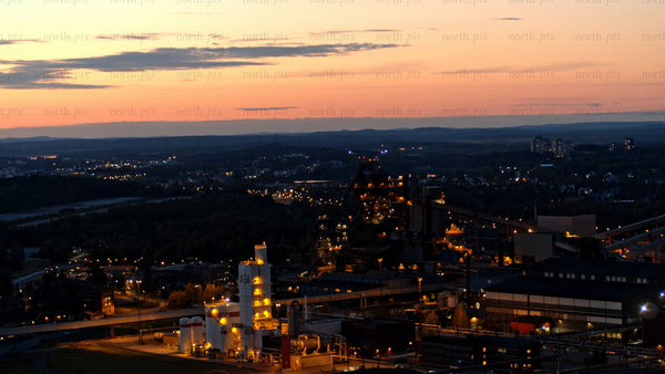 Luleå at dusk: Aerial view of cityscape, industrial buildings, and sunset sky