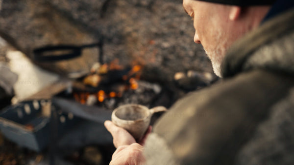 Cozy campfire moment with hot drink in winter, Luleå archipelago