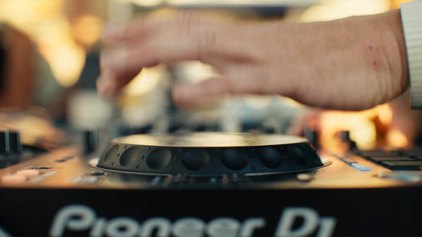 DJ's hands mixing music at a summer outdoor party: Close-up on the mixer