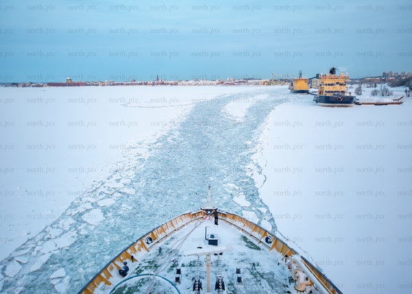Icebreaker ship navigating frozen waters during winter after bright morning
