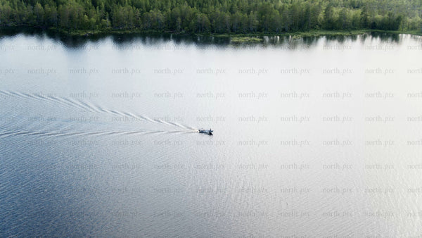 Summer evening boat trip on a calm lake near Luleå
