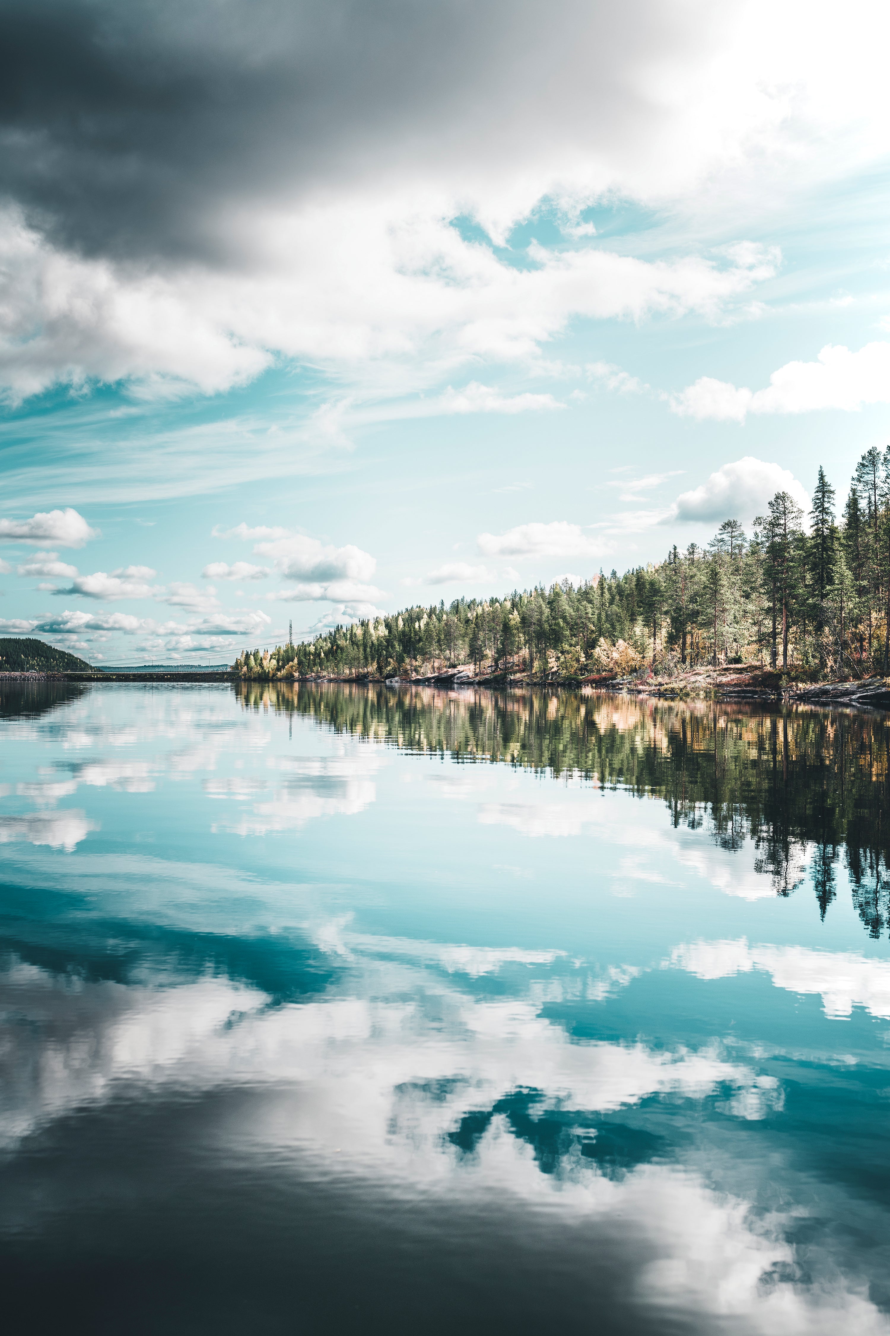 Lake with forested shoreline and sky reflection