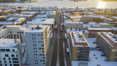 Lulea, Sweden Winter Cityscape: Aerial Drone Timelapse of Snowy Streets and Frozen River at Sunset