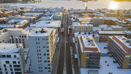 Luleå, Sveriges vinterstadsbild: Flygfoto över drönarens timelapse av snötäckta gator och frusen flod i solnedgången