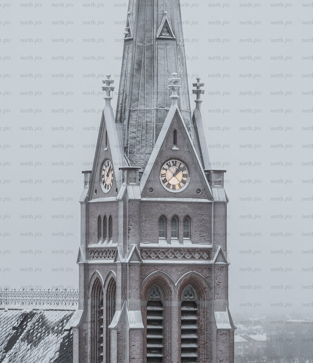 Church clock tower covered in snow on winter morning