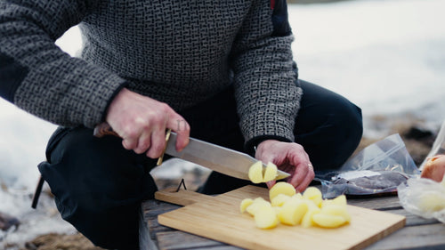 Man hackar potatis utomhus på vintern nära Luleå, Sverige