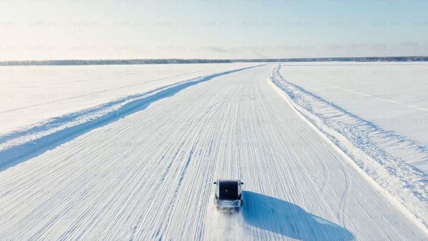 Tesla/car winter driving on frozen ice road in Luleå - drone footage