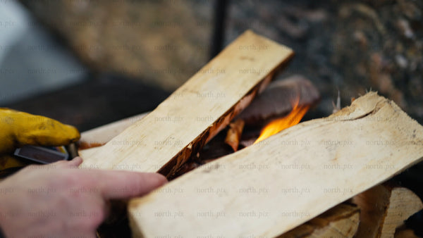 Adding firewood to a winter fire in the Luleå archipelago