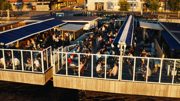 Aerial view of floating restaurant on Luleå river in summer evening with people enjoying drinks and food