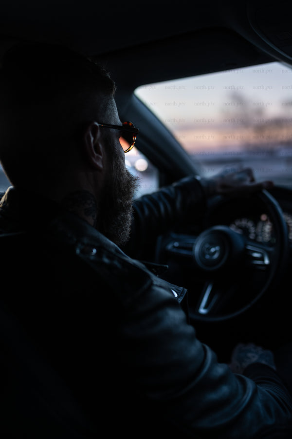 Man driving car at dusk, interior view