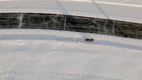 Flygfoto över person som drar släde på frusen älv i Luleå, Sverige, på en solig vinterdag