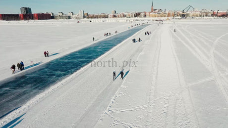 Winter Day in Luleå: People Enjoy Skating and Walking on a Frozen Waterway