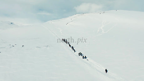 Group Hiking Up Snowy Mountain in Riksgränsen, Sweden