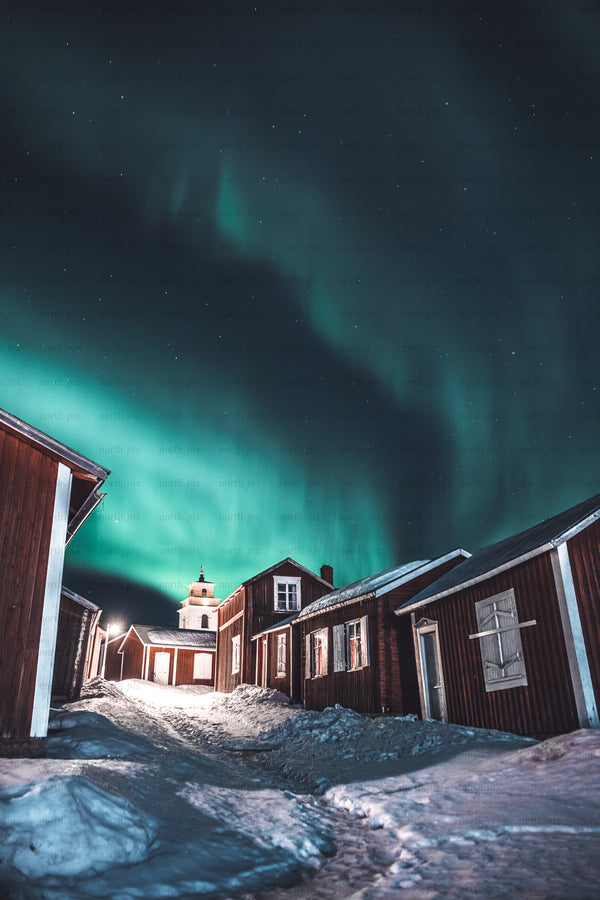 Northern Lights over church village with red houses