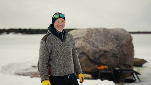 Man står vid frusen sjö i snöigt vinterlandskap, Luleå skärgård, Sverige