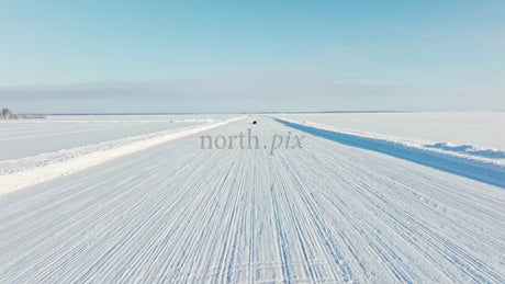 Tesla/Car Driving on Snowy Ice Road in Luleå, Sweden - Winter Drone Shot
