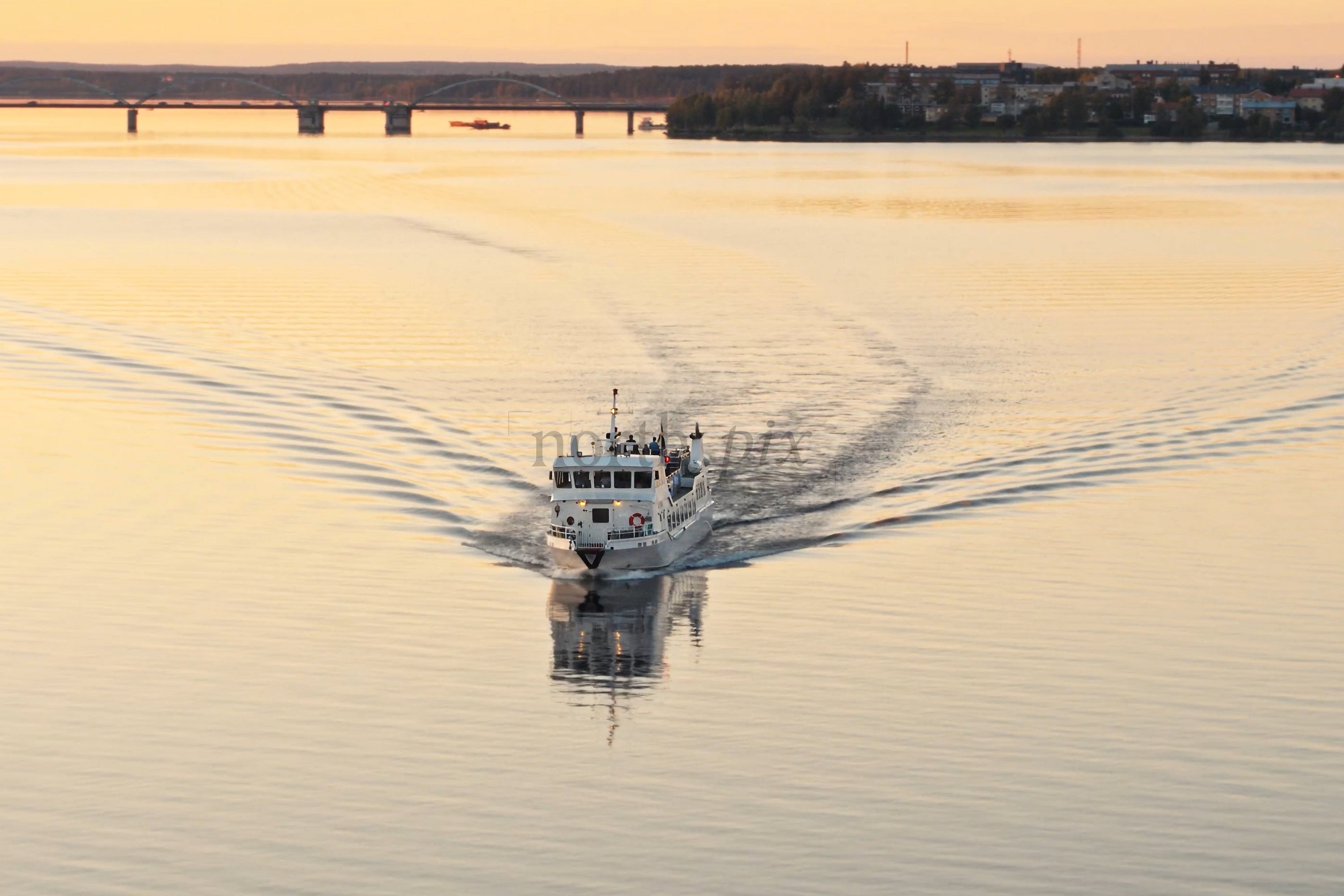 Sunset Boat Cruise Over Calm Water Near Luleå City Center Bridge and Skyline