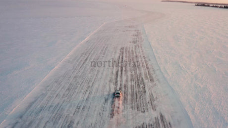 Driving Car on Frozen Ice Road in Luleå Archipelago during Winter Sunset