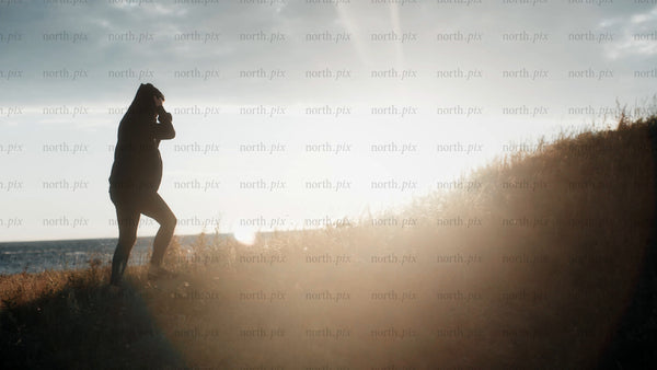 Silhouette walking up hill during golden hour in Luleå