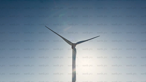 Rotating wind turbine against blue sky, clean energy generation