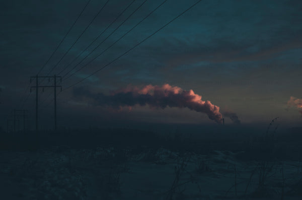 Power lines and factory smoke at dusk in winter