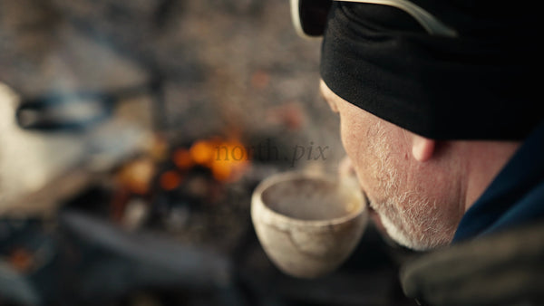Man Enjoys Hot Drink by Campfire in Winter, Luleå Archipelago, Sweden