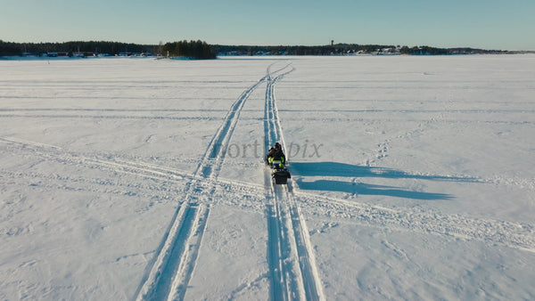 Snowmobile Adventure on Frozen Lake in Lulea, Sweden: A Sunny Winter Day