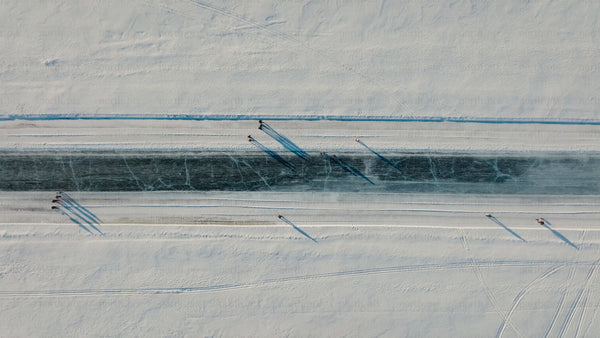 Aerial view of frozen river in Luleå with people skating and walking in winter