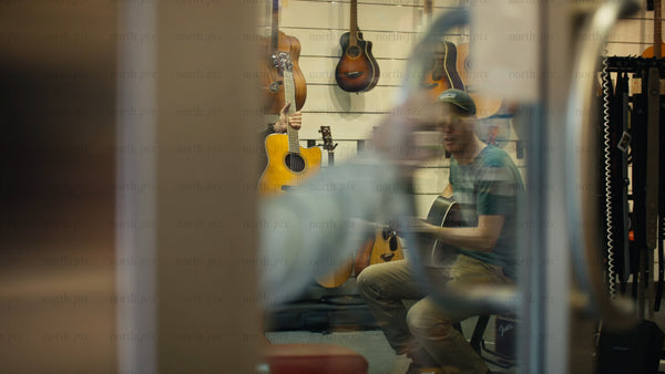 Man trying out an acoustic guitar in a music store