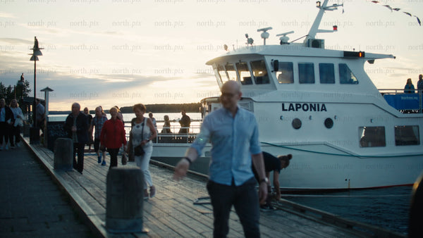Passengers disembarking ferry at sunset on Luleå pier