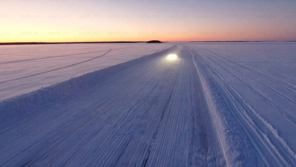 Driving on a snowy ice road in Luleå at sunset