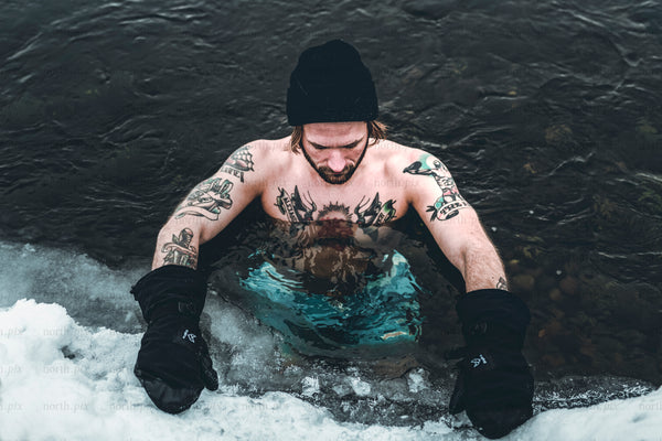 Shirtless man in river during winter