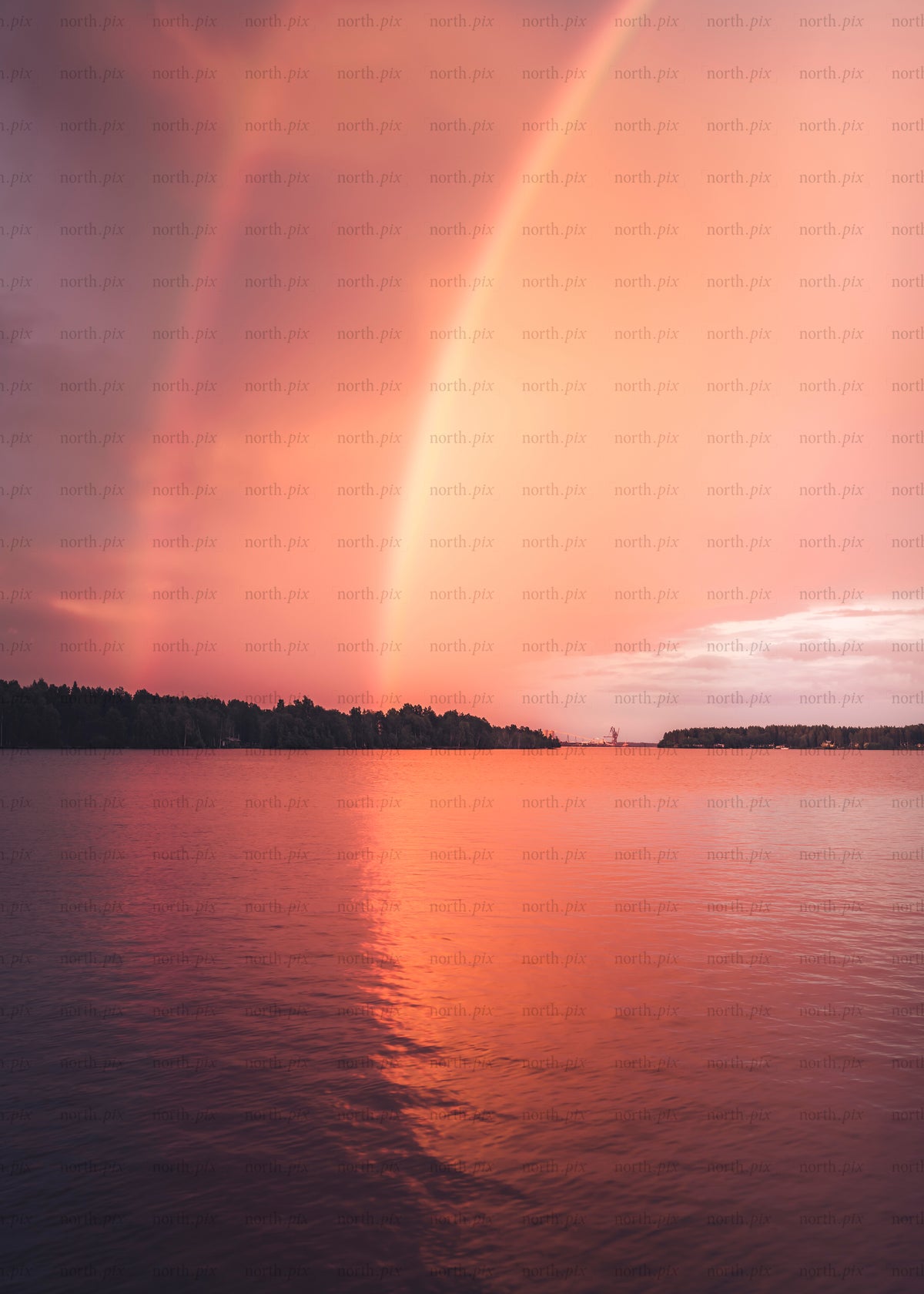 Rainbow over lake at sunset with reflection