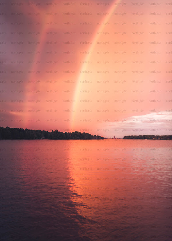 Rainbow over lake at sunset with reflection