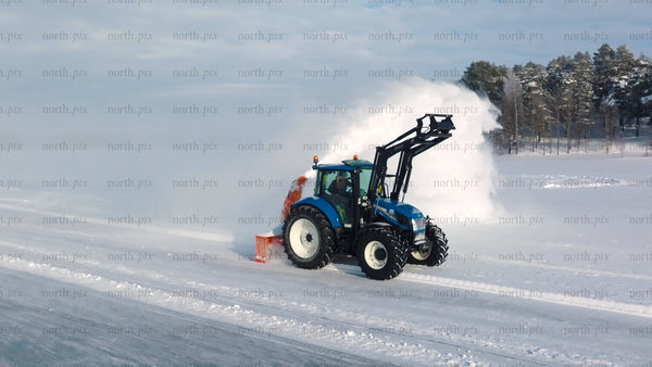 Tractor clearing snow on frozen lake in Luleå