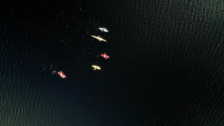 Kayaks Gliding on Dark Water in Luleå, Sweden - Drone Aerial View