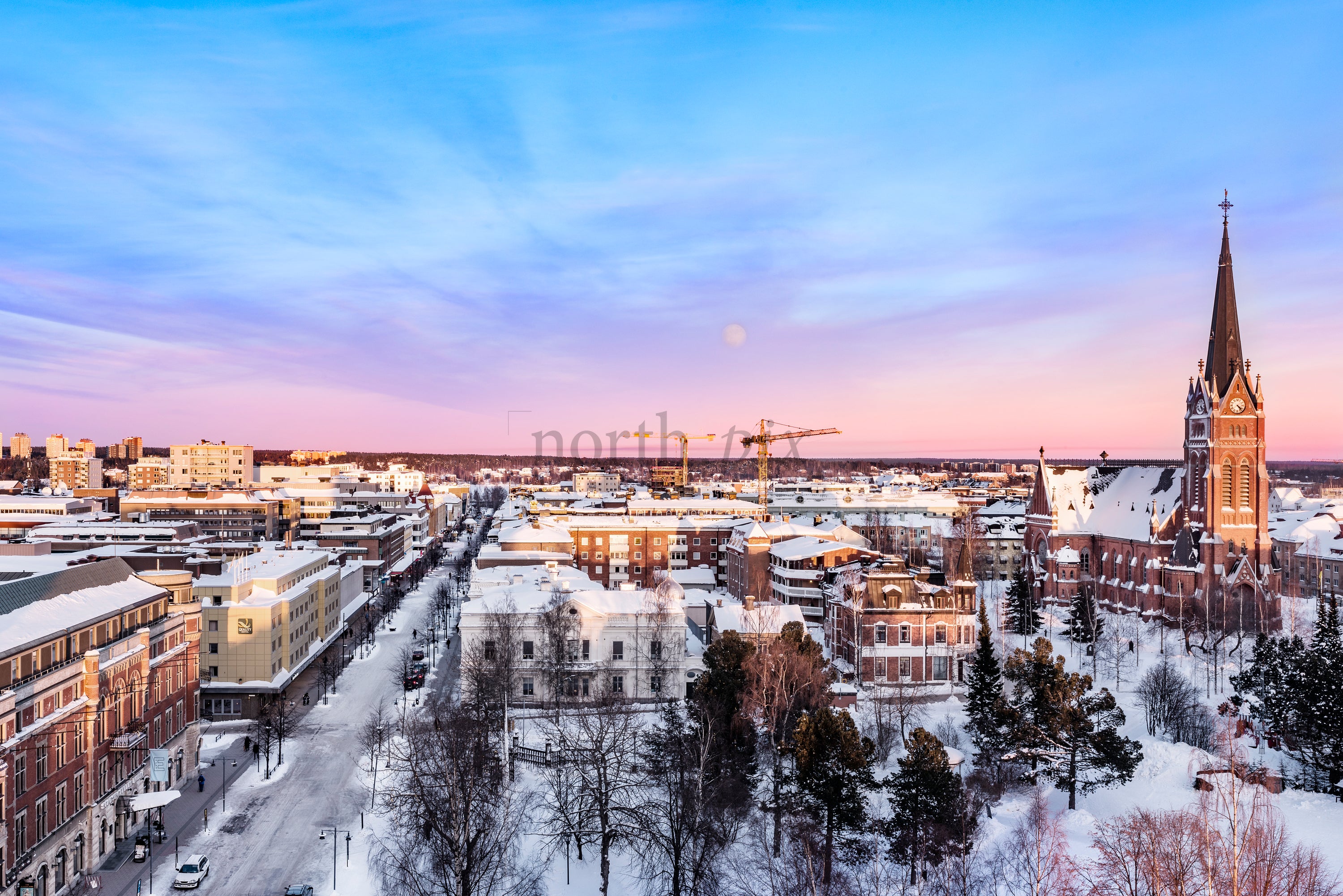 Sunrise Over Winter Cityscape of Luleå With Church Spire, Snow-Covered Streets and Pastel Sky