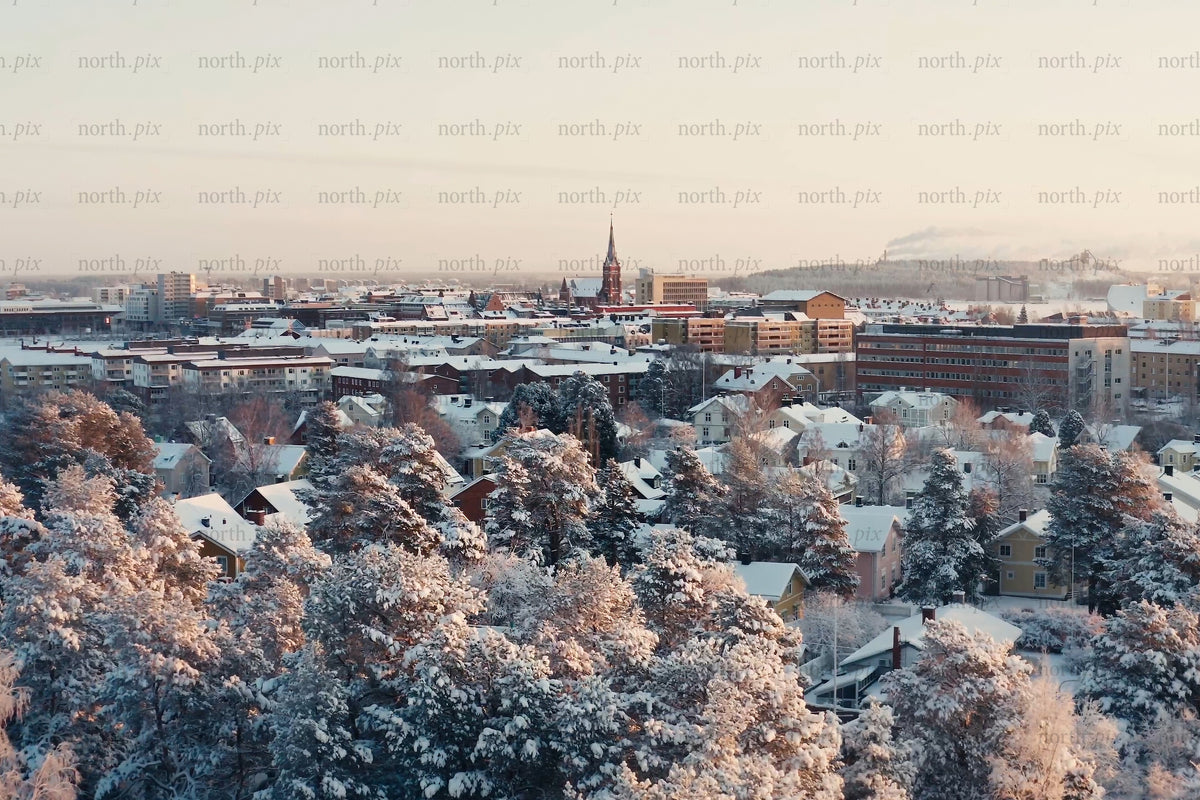 Snowy city center view over Luleå with trees, homes, and winter lighting