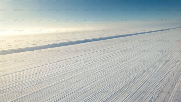 Driving on a snowy ice road in the Luleå archipelago - winter drone view