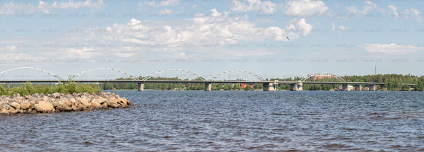 Panoramic view of arched bridge over river, summer afternoon