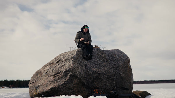 Man Eats Lunch by Fire on Frozen Luleå Archipelago, Sweden, in Winter