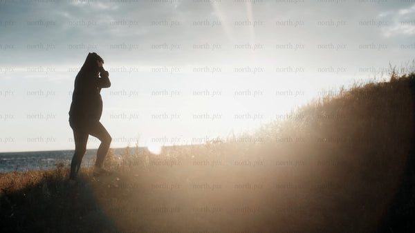 Silhouette walking up hill during golden hour in Luleå