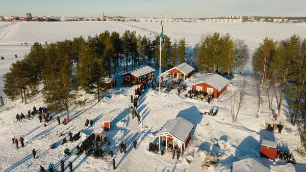 Winter fun in Luleå: Aerial view of ice skating, snowmobiling, and sledding on a frozen lake