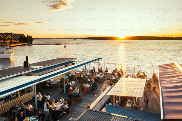 Lively waterfront dining at sunset in Luleå during summer