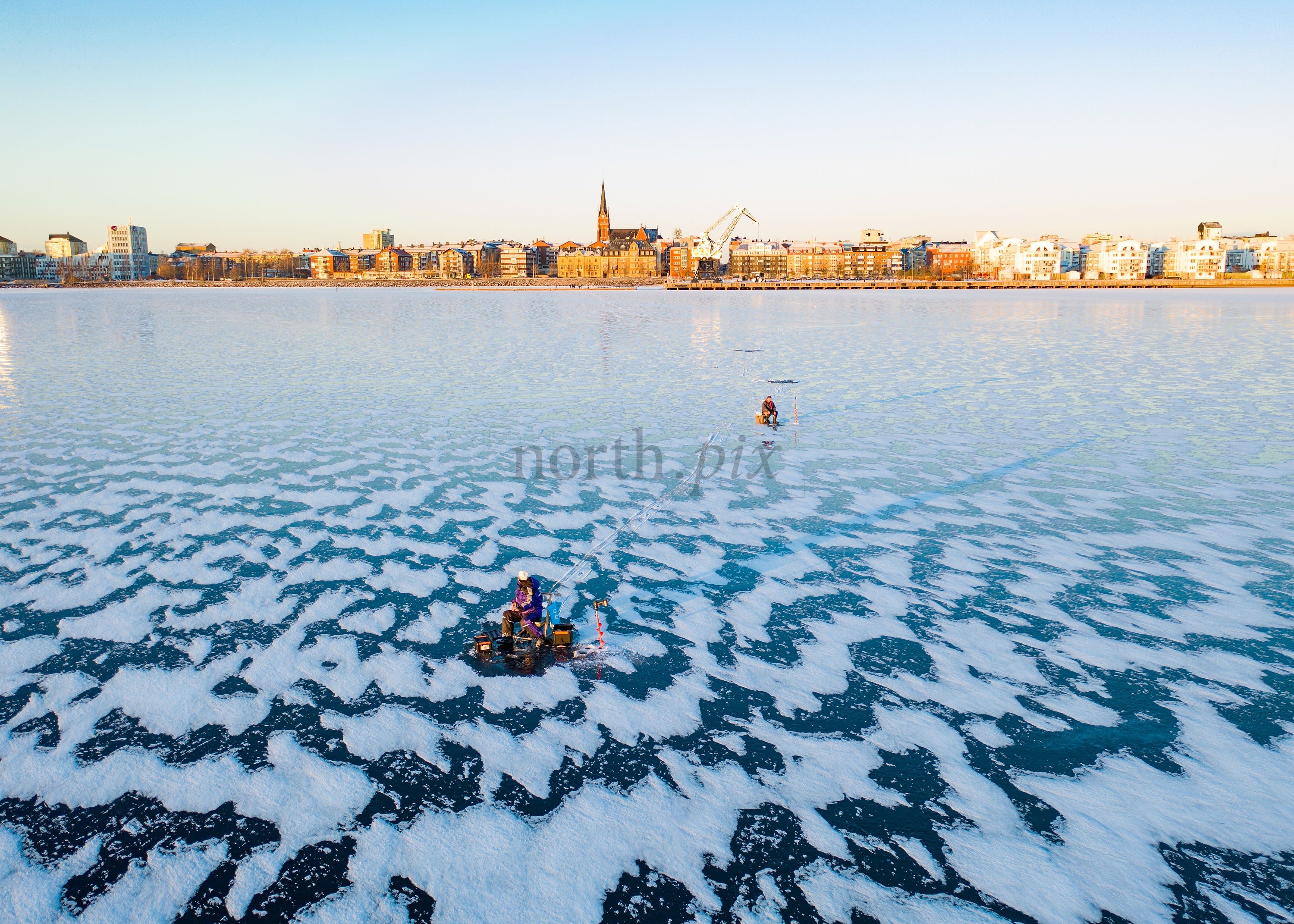 Winter Cityscape View of Frozen Lake with People in Morning Light