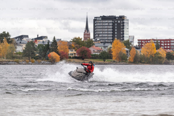 Person riding a jet ski on a lake in autumn