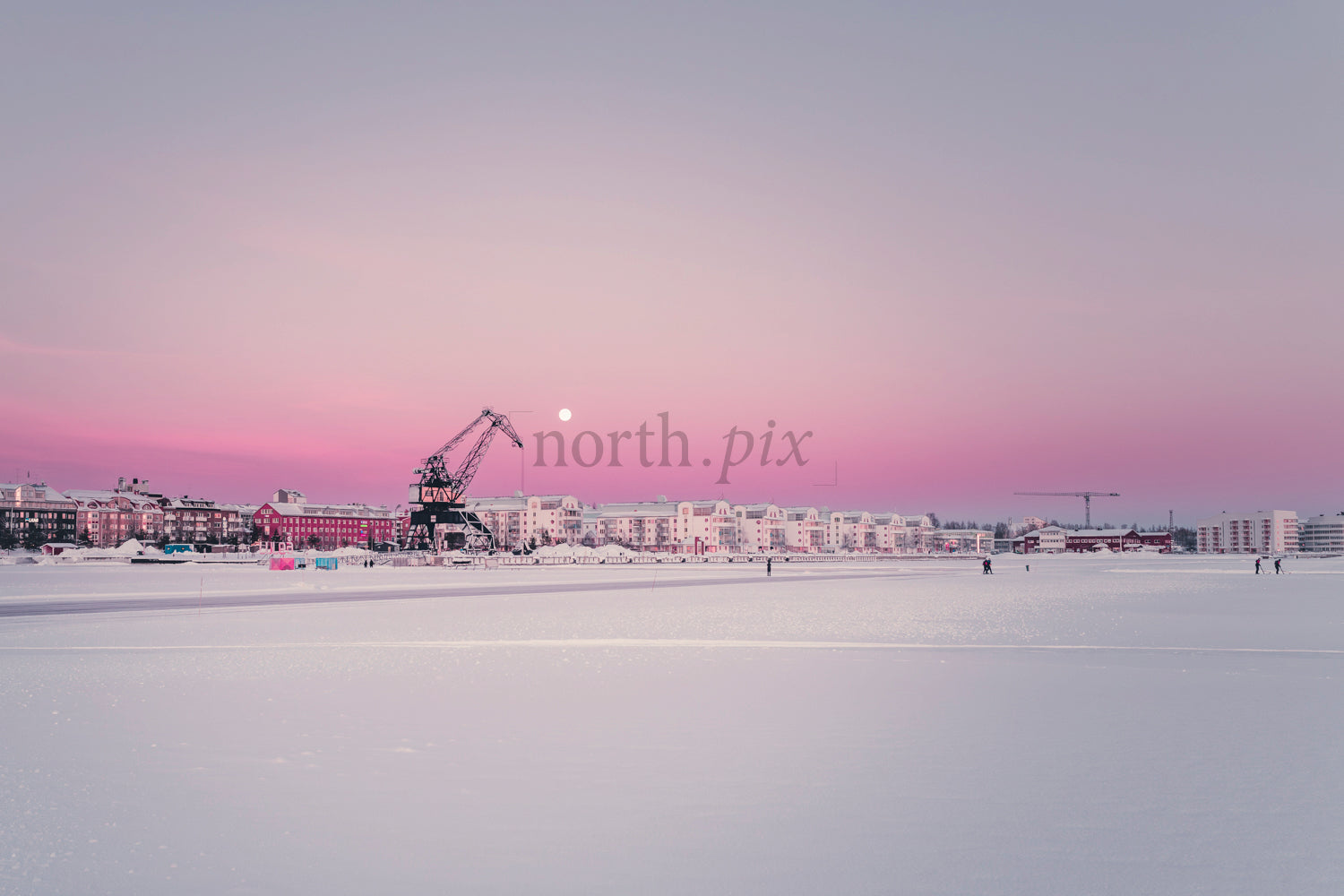 Harbor crane and waterfront buildings at sunrise