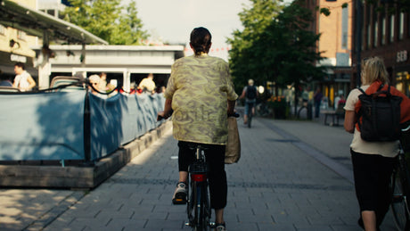 Woman on Bicycle in Lulea City Street During Sunny Summer Day