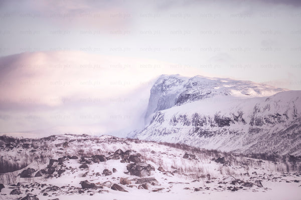 Stora sjöfallet - snow-covered mountain at sunrise with rocky foreground
